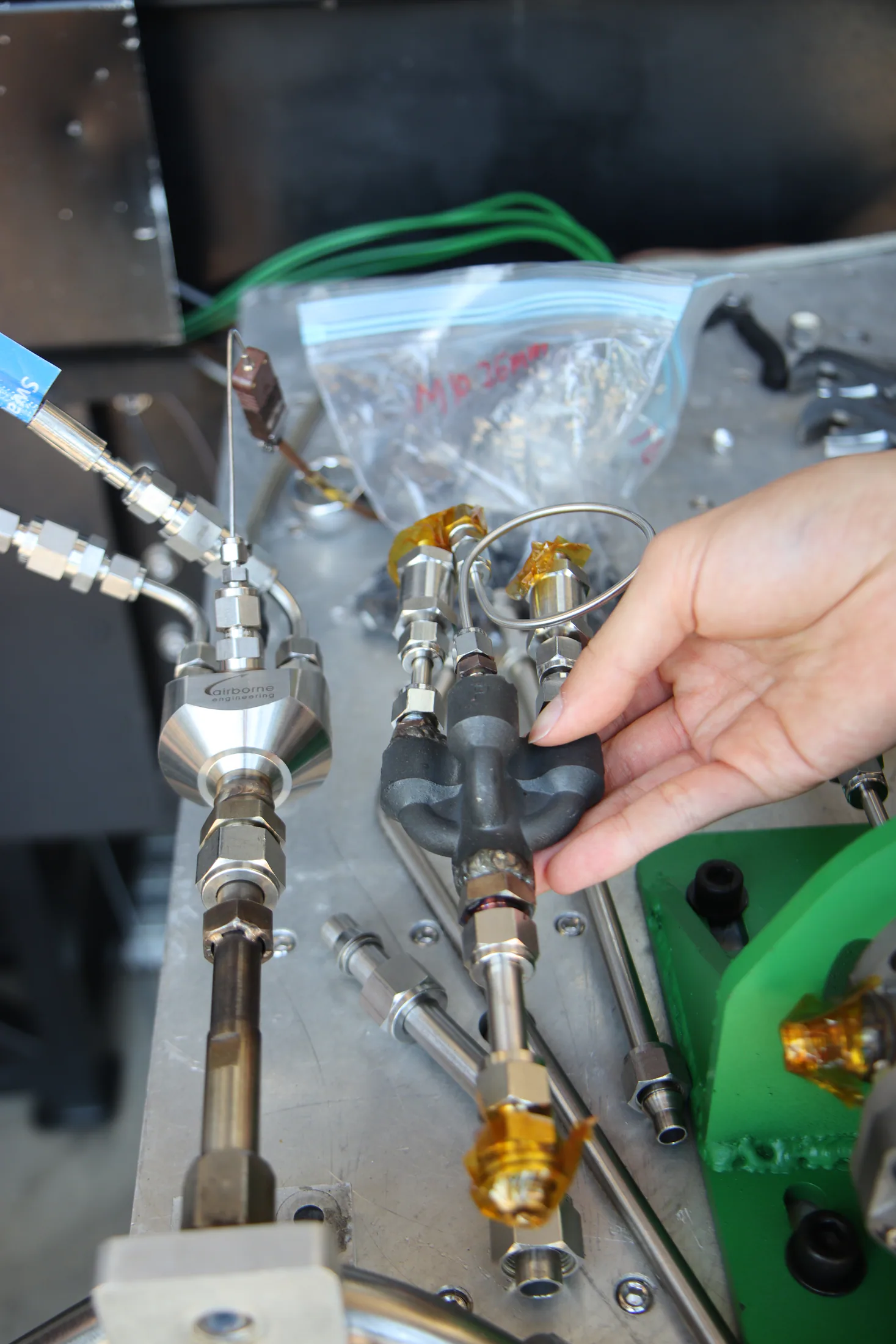 Close-up of metal feed lines, valves, and fittings connected to the mounted engine hardware.