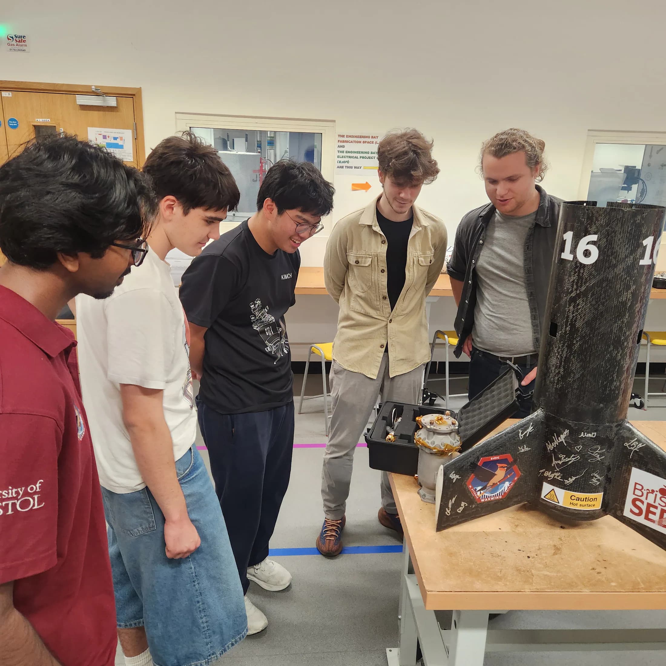 Students continuing a close inspection of the rocket body and exposed internal area.