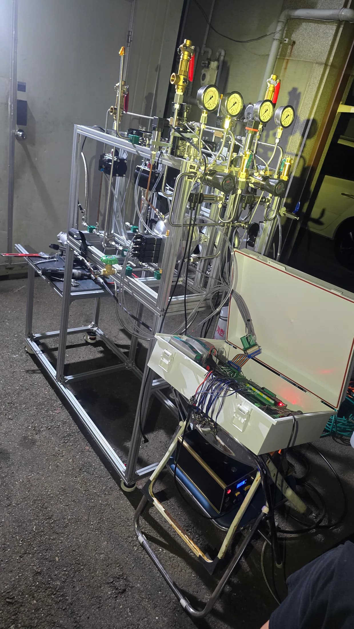 Full ground-test stand with plumbing, valves, and its open control electronics box.