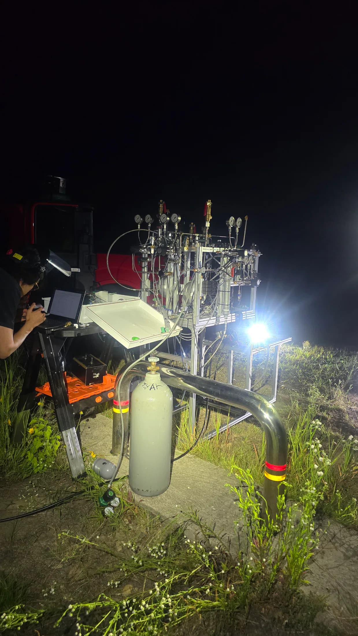 Outdoor night test setup with an operator beside the illuminated stand.
