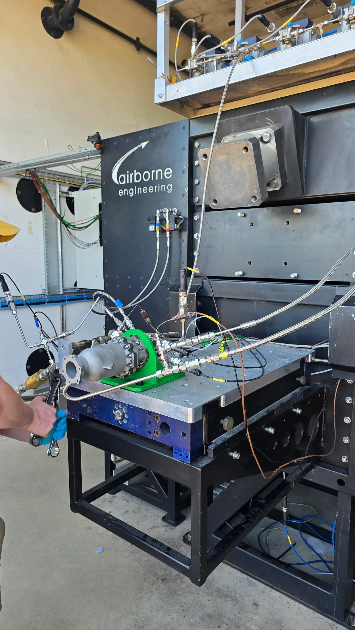 Kimchi engine test rig mounted inside the facility with pipes, cables, sensors, and chamber hardware.