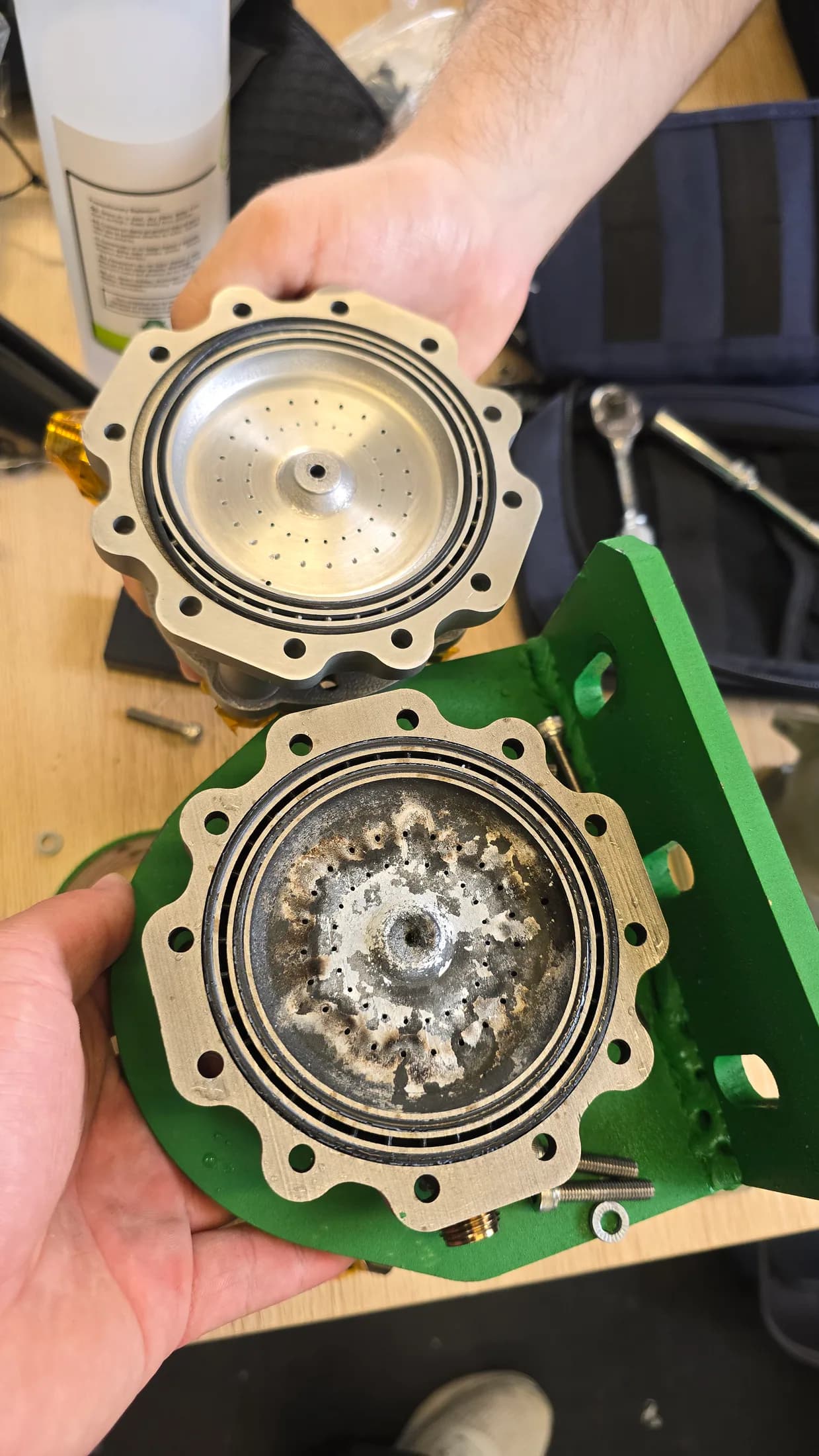 Separated circular engine components held after testing, showing the internal post-test condition.