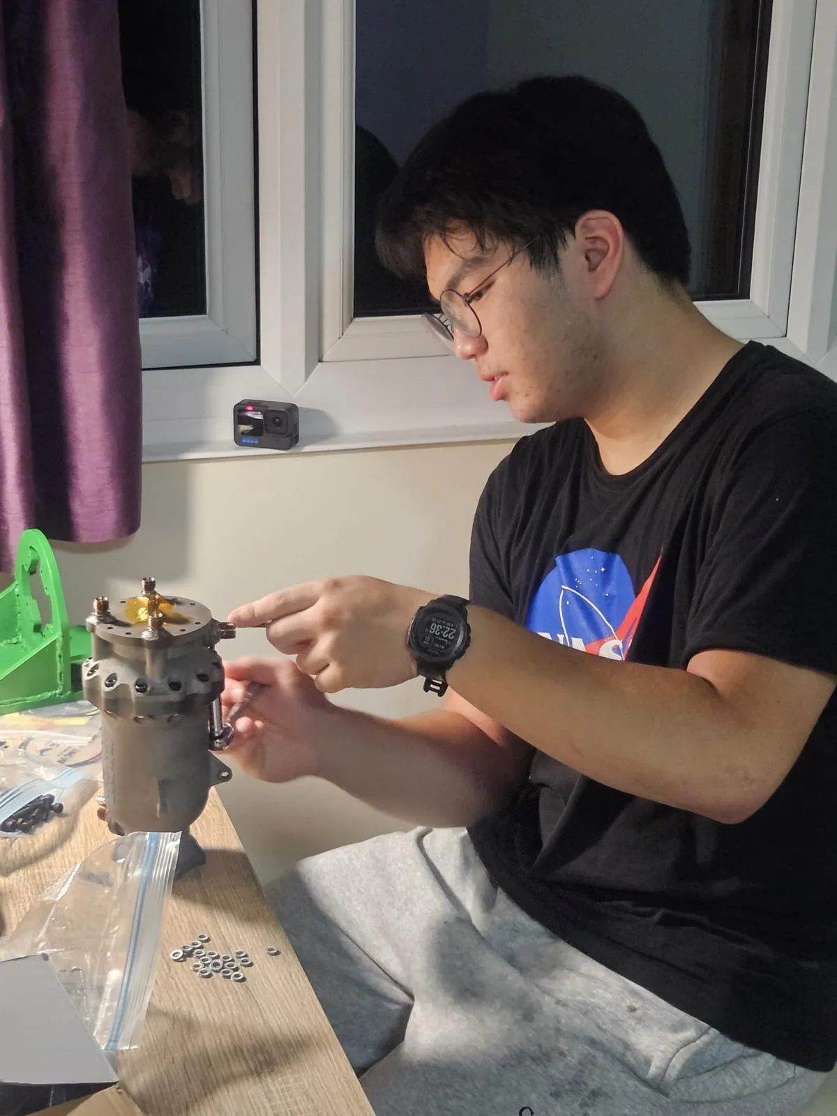Person assembling the Kimchi engine at a desk on the night before testing.